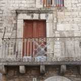 Al portale ad arco segue al secondo livello un balconcino dalle ringhiere in ferro ed una finestra frontonata...